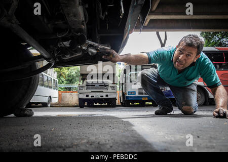 10 agosto 2018, Venezuela, Caracas: un uomo esamina un bus permanente su un sito di grandi dimensioni. Molti autobus non può essere riparato a causa della mancanza di parti di ricambio in crisi in Venezuela. Alcune linee di autobus sono stati annullati. A causa della manutenzione del precedente miliardi di dollari di sovvenzioni, la benzina è ancora più conveniente di acqua in Venezuela. Tuttavia, il carburante è presto per essere venduti a prezzi internazionali. Il Venezuela ha a lungo sofferto di una grave crisi economica e di crisi di approvvigionamento. Il paese con il più grande del mondo di riserve di petrolio sta lottando con iperinflazione, il che significa che i prezzi sono cresciuti in modo vertiginoso e denaro è rapida Foto Stock