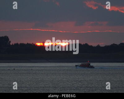 Sheerness, Kent, Regno Unito. 14 Ago, 2018. Regno Unito Meteo: la barca del pilota passa il sole di setting in Sheerness, Kent. Credito: James Bell/Alamy Live News Foto Stock