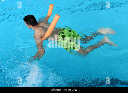 Hannover, Germania. 10 Ago, 2018. Con il supporto di un nuoto aiuto un giovane uomo impara a nuotare in Foessebad piscina. Credito: Holger Hollemann/dpa/Alamy Live News Foto Stock