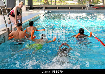 Hannover, Germania. 10 Ago, 2018. Insegnante di nuoto Diandra Rother dà lezioni di nuoto per giovani uomini dall'Afghanistan, Iraq, Sudan e Costa d Avorio in Foessebad piscina. Credito: Holger Hollemann/dpa/Alamy Live News Foto Stock