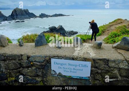 Un fotografo femmina sulle scogliere a Hartland Quay Foto Stock