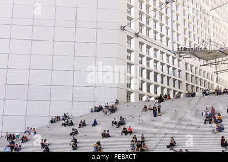 La gente seduta sulle scale di La Grande Arche de La Defense area di Parigi, Francia. Foto Stock