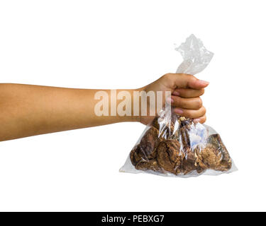 Canto isolato : una femmina tagliate a mano nera di contenimento di funghi secchi nella sacca di plastica trasparente su sfondo bianco includono tracciato di ritaglio di facile utilizzo f Foto Stock