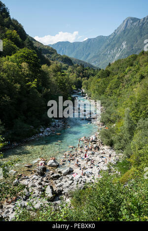 La gente che prende il sole e fare il bagno nel fiume Soca in estate in Kobarid, Slovenia Foto Stock