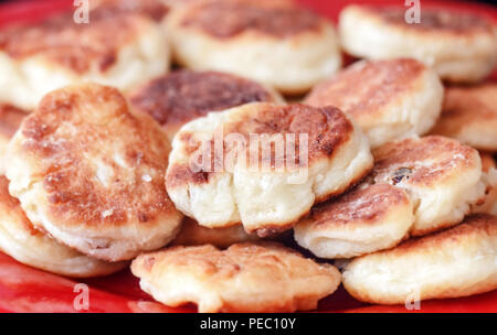 Home reso syrniki sulla targhetta rossa per la gustosa prima colazione Foto Stock