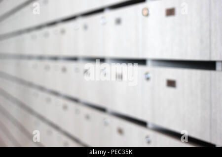 Foto sfocate di caselle di posta e pacchi in un palazzo di appartamenti Foto Stock