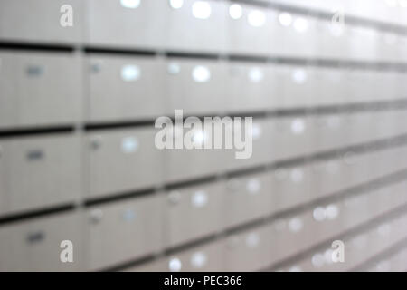 Foto sfocate di caselle di posta e pacchi in un palazzo di appartamenti Foto Stock