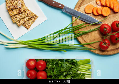 Lay piatto con il coltello e il cibo sano composizione isolata su blu Foto Stock