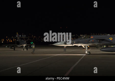 Colombiano di Air Force Kfir fighter jet capo equipaggio segnala un Kfir pilota sul flightline in preparazione di una missione di notte volo mentre un altro Kfir taxi durante la bandiera rossa 18-3 presso la Base Aerea Militare di Nellis Nev., 31 luglio 2018. Il Colombiano Air Force Kfir figher getti sono la formazione a fianco degli Stati Uniti Forze per la bandiera rossa 18-3 in realistico air-air Combat training scenari. (U.S. Air Force photo by Staff Sgt. Angela Ruiz) Foto Stock