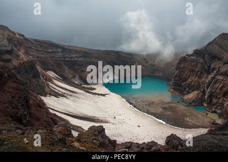 Fumarola per la cottura a vapore con il lago del cratere del vulcano Gorely, Kamchatka, Russia Foto Stock