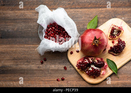 Frutti di melograno con grani sul tavolo di legno. Vista dall'alto. Fare succo. Foto Stock