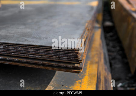 Le lamiere di acciaio depositato in pile in confezioni presso il magazzino dei prodotti in metallo. Metalli spiovente foglio per costruzione. La corrosione del metallo Foto Stock