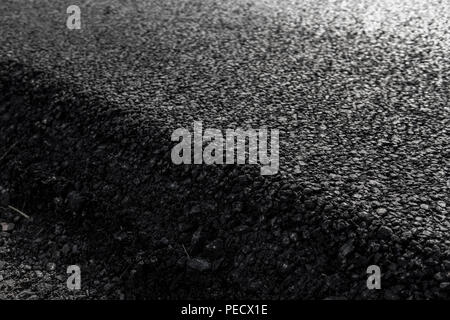 Close-up su uno strato di nuovo asfalto per la strada in costruzione Foto Stock