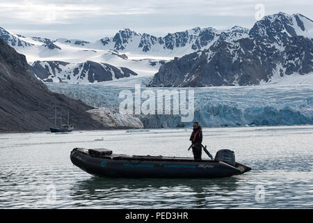 Fjortende Julibreen e Fjortende Julibukta. Ghiacciaio e fiordo con uno zodiaco e nave a vela Antigua di fronte. Spitsbergen, Svalbard, Norvegia Foto Stock