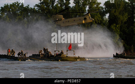 Un esercito riserva CH-47 elicottero Chinook assegnato al Bravo Company, 7/158th aviazione, Fort Hood in Texas, offre un interno bridge bay bridge di membri di equipaggio con l'Ingegnere 502nd Company (multiruolo ponte), da Fort Knox, Ky., durante il funzionamento il fiume Assault 2015 a Fort Chaffee, arca. ago 4. Soldati provenienti da vari riserva di esercito e attiva le unità di dovere allenati insieme all'esercizio, una formazione di bridging esercizio di esercito di ingegneri e di altri elementi di supporto per la creazione di un ponte modulare sull'acqua. (U.S. Esercito foto di Sgt. Jeff Shackelford) Foto Stock