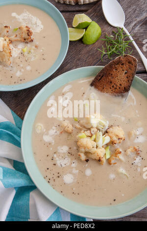 Piastra della zuppa cremosa con arrosti di cavolfiore e cipolline Foto Stock