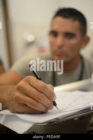 Stati Uniti Air Force Staff Sgt. Brian Milner, 341 operazioni mediche Squadron, 341 Medical Group, fuori di Malmstrom Air Force Base, Mo., scrive le informazioni sul paziente al dottor Salvador Paredes Ospedale di emergenza in Trujillo, Honduras, 7 agosto 2015. Il team medico degli elementi provvisti di emergenza supporto camera come parte dei nuovi orizzonti Honduras 2015 esercizio. Nuovi Orizzonti è stato lanciato negli anni ottanta ed è un misto annuale di assistenza umanitaria di esercizio che U.S. Comando Sud conduce con un partner nazione in America Centrale e America del Sud o dei Caraibi. L'esercizio migliora joi Foto Stock