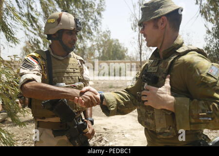 Un soldato australiano Assegnato a gruppo attività Taji scuote le mani con un soldato iracheno assegnato alla XXIII brigata durante le operazioni in ambiente urbano della formazione di Camp Taji, Iraq, e il Agosto 8, 2015. Le forze della coalizione sono attualmente la formazione quasi 700 le forze di sicurezza irachene a Taji. Attraverso la consulenza e assistenza e la costruzione di capacità del partner missioni, la Combined Joint Task Force - Funzionamento inerenti risolvere la coalizione multinazionale ha addestrato più di 11.000 iracheni forza di sicurezza personale per sconfiggere lo Stato islamico dell Iraq e il levante. (U.S. Esercito foto di Spc. William Marlow/rilasciato) Foto Stock