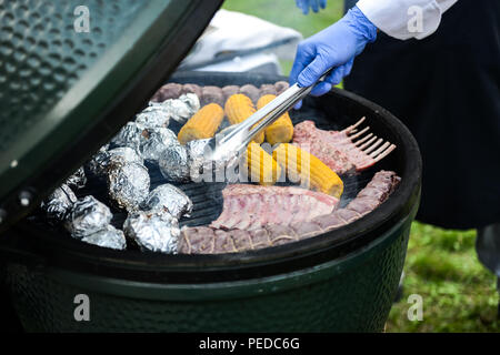 Close up uomo cibo per grigliare sul barbecue Foto Stock