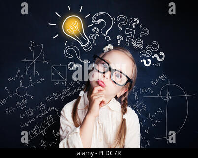 Bambino Piccolo matematica studente pensare sullo sfondo con lampadina e formule matematiche. Kid idee Foto Stock