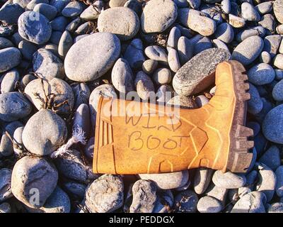 Rifiuti pericolosi su una spiaggia sassosa. Fotografia che mostra il problema dell'inquinamento. Rifiuti pericolosi espulso dal mare sulle spiagge remote. Foto Stock