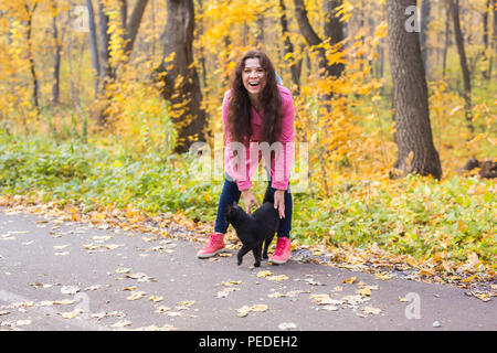 Animali domestici, della natura e del concetto di persone - una bella donna sorridente trovato il gatto nero Foto Stock