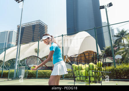 Allegro bella donna di giocare a tennis in una città sviluppata Foto Stock