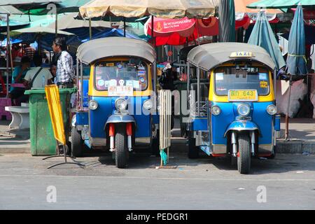 BANGKOK, Tailandia - 22 dicembre 2013: Le persone camminano in tuk tuk i taxi di Bangkok. Bangkok è la città più grande della Tailandia con 14 milioni di persone che vivono Foto Stock