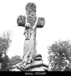 Bella foto in bianco e nero prese nel cimitero di Greenwood di un famoso oggetto contrassegnato per la rimozione definitiva, di una donna che tiene una croce. Foto Stock