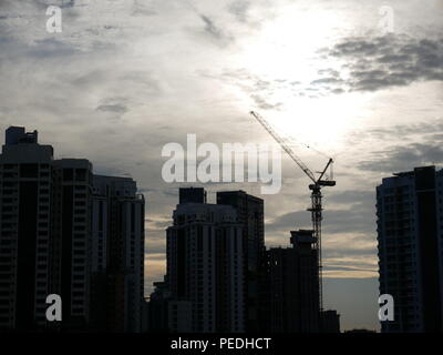 Tramonto dietro gli edifici con un bellissimo cielo nuvoloso. Bel rosso, viola e le sfumature di blu del tramonto dietro gli edifici moderni Foto Stock