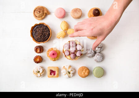 Una divertente selezione di torte e pasticcini stabilite nei modelli e isolate su uno sfondo bianco Foto Stock