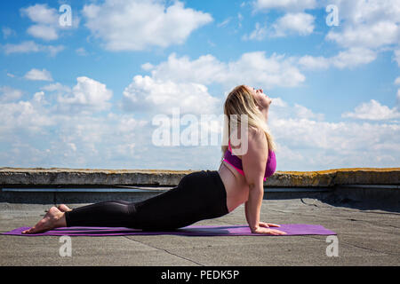 Giovane donna fare yoga, Bhujangasana Foto Stock