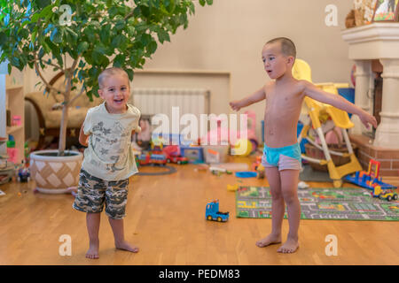 Due bambini piccoli a casa facendo sport. I bambini fanno esercizi. Due ragazzini sono a fare gli esercizi. Foto Stock