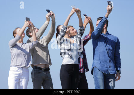 Un gruppo di giovani con gli smartphone Foto Stock