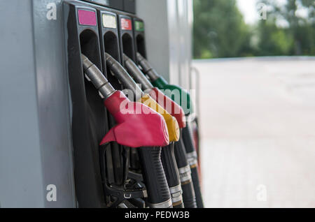 Vicino sul carburante sporco nell'ugello dispensatore di olio con benzina e diesel in servizio della stazione di gas. Modello pompa di benzina la pistola di riempimento rosso verde giallo rosa stile colorato. Energia Foto Stock