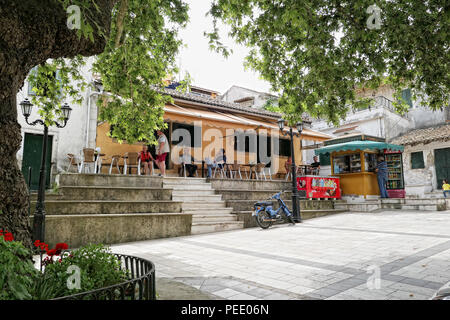 Grecia LIAPADES, CORFU / Grecia 23 Maggio 2018: Gente seduta in un ristorante al posto di mercato quadrato di Liapades. Villaggio di montagna di Corfù (Grecia) Foto Stock