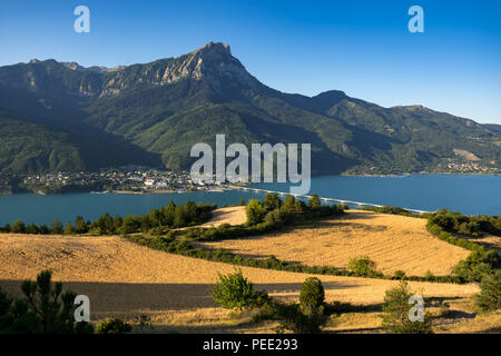 Savines-le-Lac e il Grand Morgon picco (Pic de Morgon) con Serre-Poncon lago nella luce del mattino. Hautes-Alpes, alpi, Francia Foto Stock