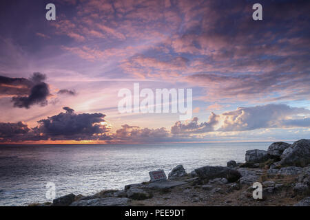 Lands End Tramonto in Cornovaglia, Inghilterra con scogli pericolosi segno Foto Stock