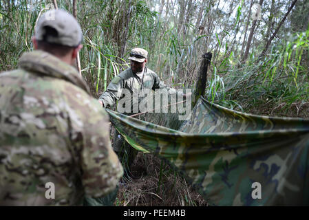 Equipaggi iscritti con la 101st Rescue Squadron costruire una trappola di acqua durante un combattimento e acqua di sopravvivenza corso di formazione ad Homestead Air Base riserva Fla., 20 gennaio, 2016. Durante questo corso di formazione, equipaggio membri guadagnato un training di aggiornamento utilizzando il proprio radio emergenza, movimenti tattici attraverso un terreno difficile, come costruzione di rifugi, modi di costruire gli incendi e i metodi per eludere il nemico. (U.S. Air National Guard / Staff Sgt. Christopher S. Muncy / rilasciato) Foto Stock