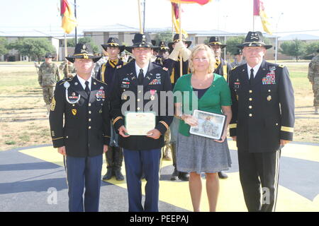 Lt. Col. Rolland Niles (secondo da sinistra), vice capo del personale con sede e Sede battaglione, 1a divisione di cavalleria, sorge accanto a sua moglie, Shawna, e il comando Sgt. Il Mag. Andrew Barteky (sinistra), 1° Cav. Div. senior advisor arruolato e il Mag. Gen. Michael bollette (destra), 1° Cav. Div. il comandante generale, dopo essersi aggiudicato la legione di merito da fatture durante il trimestrale di servizio distinto cerimonia di riconoscimento martedì sul campo Cooper a Fort Hood, Texas. (U.S. Foto dell'esercito da Staff Sgt. Christopher Calvert, 1° Cav. Div. PAO/rilasciato) Foto Stock