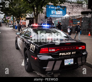 VANCOUVER, BC, Canada - 11 Maggio 2016: VPD cruiser su Vancouver Downtown Eastside di ufficiali in background ha a che fare con un problema Foto Stock