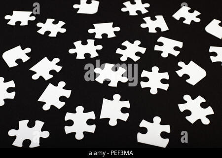 White jigsaw puzzle su nero Foto Stock