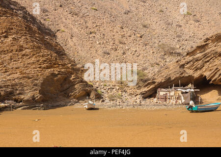 Yiti Muscat Oman beach in una giornata di sole con la torbida avente meteo montagne sullo sfondo Foto Stock
