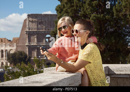 Felice giovane madre e figlia viaggiatori non lontano dal Colosseo visualizzazione di foto sulla fotocamera Foto Stock