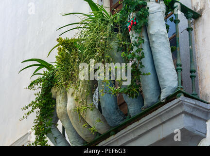 Finestra di costruzione balcone con vecchi jeans che serve come vasi di fiori Foto Stock