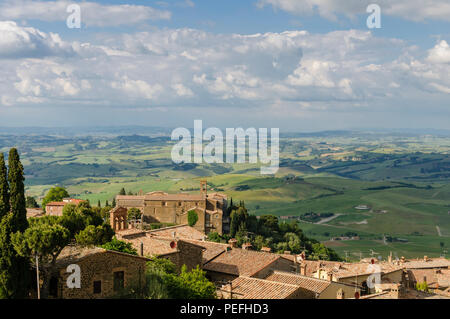 Tetti di Montalcino e vista panoramica del tipico paesaggio toscano in Val d'Orcia: colline, prati e campi verdi. Toscana, Italia, Europa Foto Stock