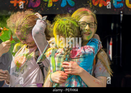 DZERZHINSK, Russia - 19 Maggio 2018: Felice ragazze giovani abbracciarsi celebra la festa di colori e di musica. Le facce sono ricoperte con polvere di colore. Foto Stock