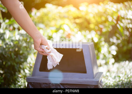 La Giornata Mondiale dell Ambiente, 5 giugno. Donna mano azienda e mettendo carta tessuto i rifiuti nel cestino rifiuti. Foto Stock
