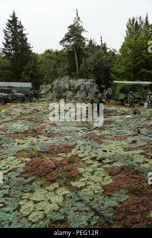 Soldati ceca di luce 74Battaglione motorizzato, 7° Brigata meccanizzata, lay out camouflage per essere collocato sopra le tende mentre trasferiscono i loro tactical operations center durante l'esercizio Allied Spirit II presso l'U.S. Dell'esercito multinazionale comune disponibilità centro in Hohenfels, Germania, Agosto 16, 2015. Allied Spirit II è una multinazionale decisa azione ambiente formazione esercizio che coinvolge oltre 3.500 soldati provenienti da entrambi gli Stati Uniti, alleati e nazioni partner focalizzata sulla creazione di partenariati e di interoperabilità tra tutte le nazioni partecipanti e sottolineando la missione il comando, intelligenza e sostenere Foto Stock