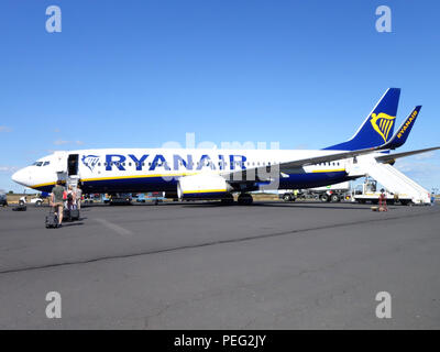 Passeggeri a piedi attraverso la tarmac verso loro homeward volo su un aereo Ryanair Foto Stock